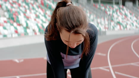 Handporträt-Einer-Kaukasischen-Frau,-Die-Nach-Einem-Lauf-Auf-Einer-Leeren-Stadionstrecke-Am-Frühen-Morgen-Nach-Luft-Schnappt.-Aufgenommen-Mit-Einem-Anamorphotischen-Objektiv